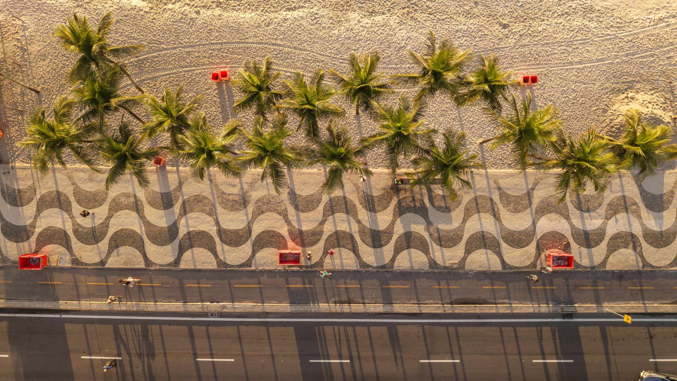 Aerial view of Copacabana Beach in Rio de Janeiro showcasing palm trees and iconic wavy pavements.